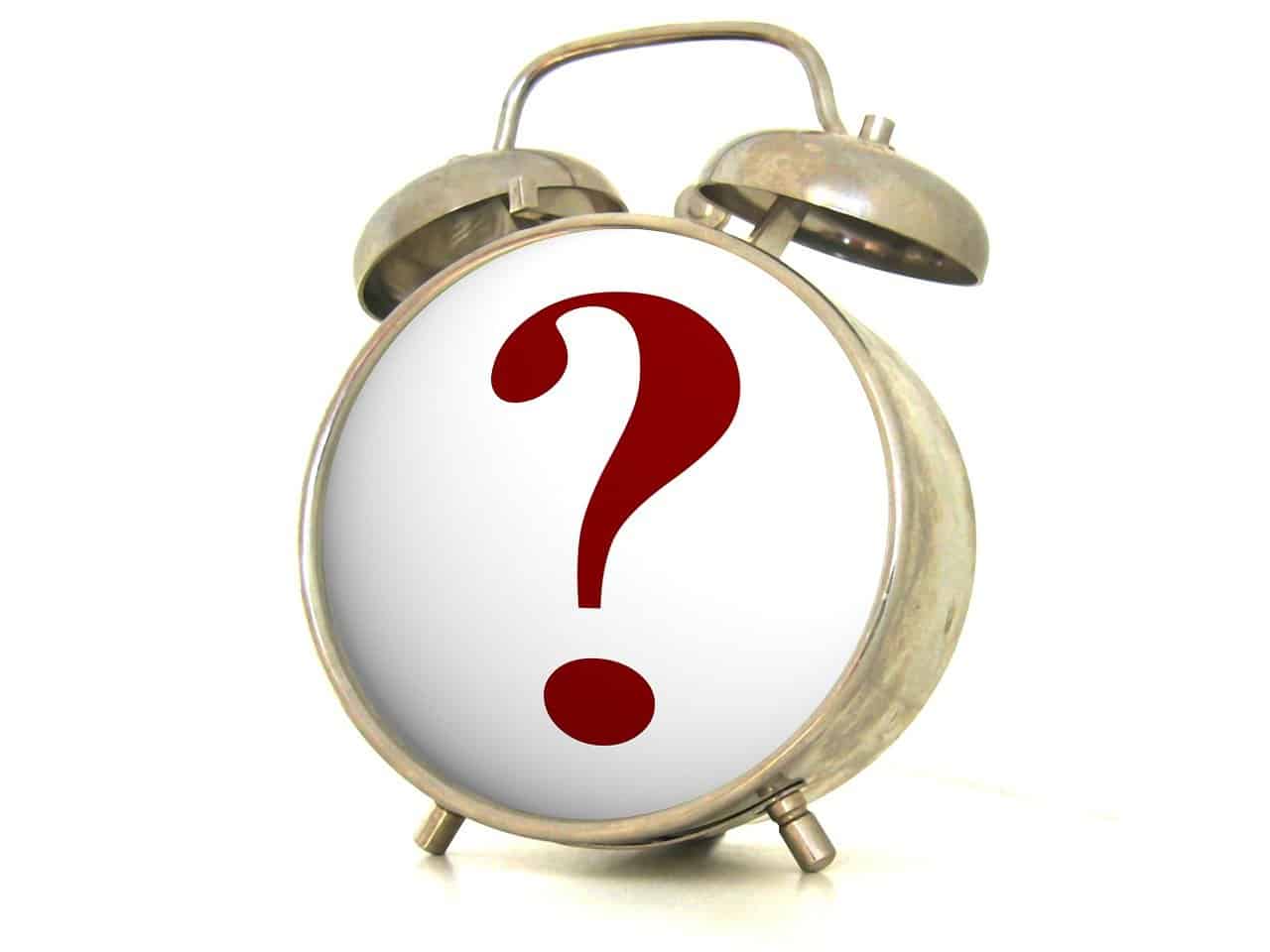 Alarm clock with a large red question mark on the face, symbolizing the importance of asking the right questions in decluttering and organization.